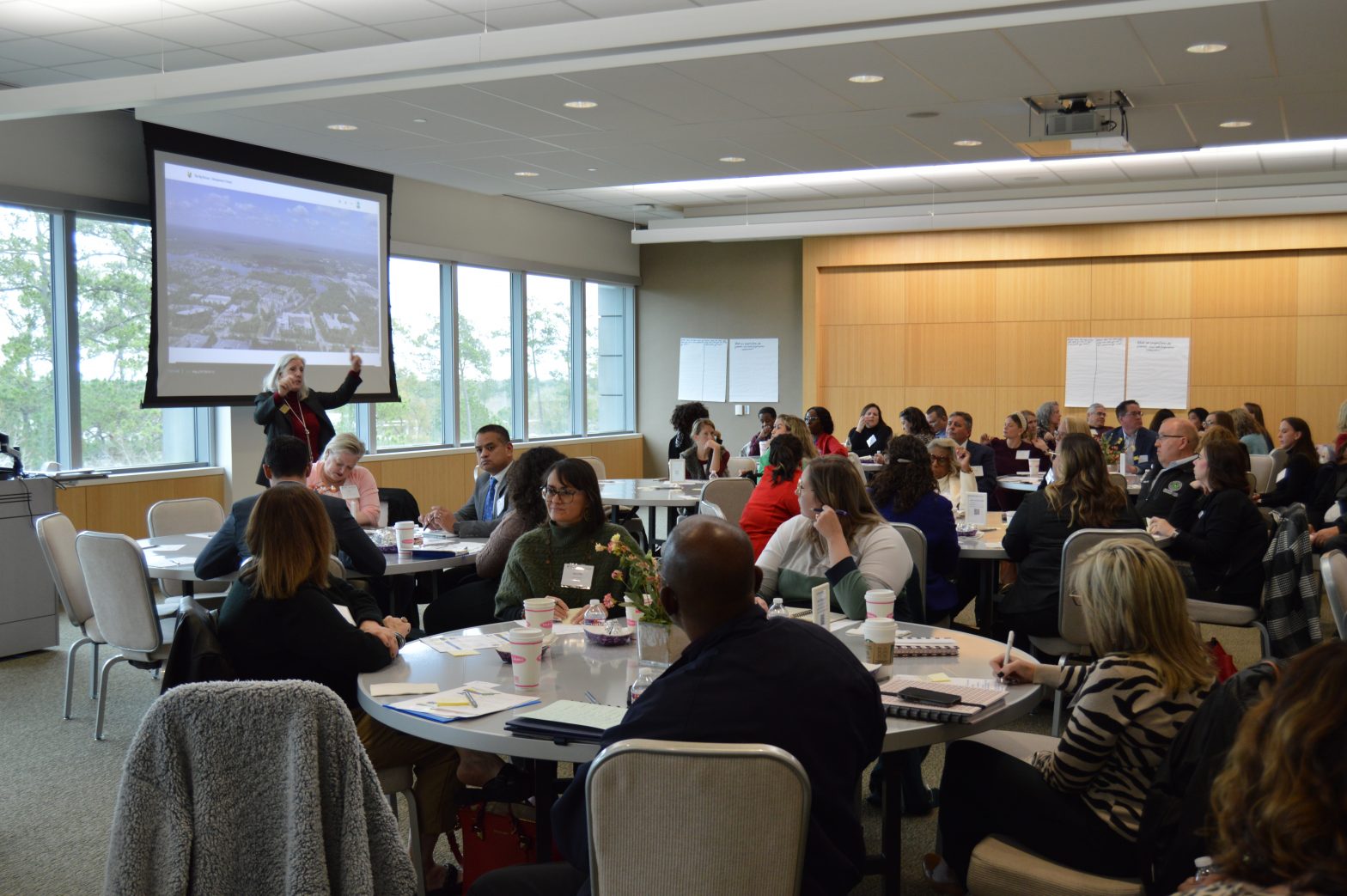 Picture of full room at the Big Picture convening in Montgomery County, with Julie Martineau, Presidents & CEO of Montgomery County Community Foundation, presenting